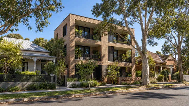 An Australian neighbourhood with eucalyptus trees, shaded homes and masonry infill.