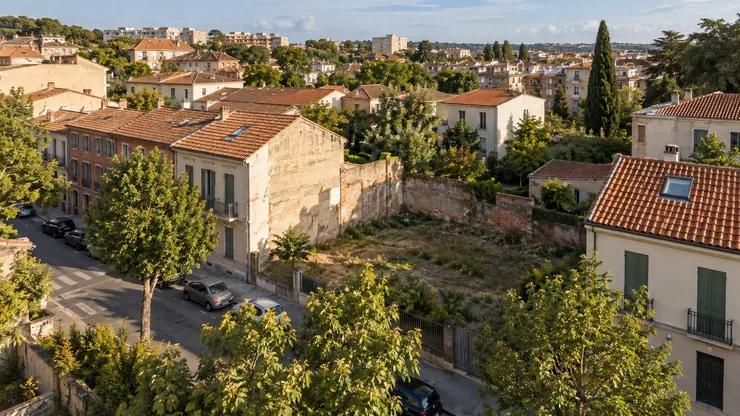 An urban neighbourhood with varied buildings, green spaces and an open infill plot.